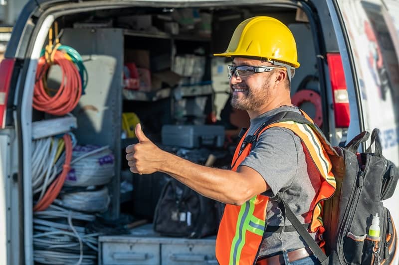 Smiling Hispanic Construction Worker Wearing A Work Helmet Looking Away With His Thumbs Up Cm