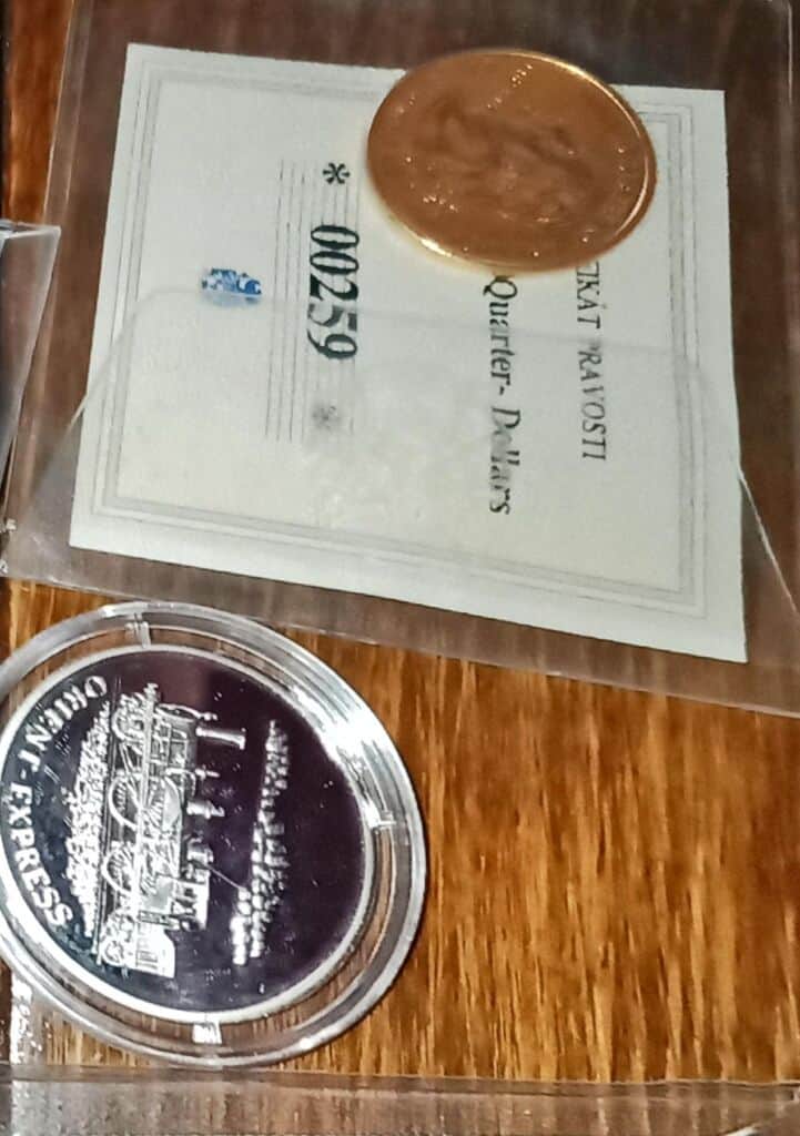 Zlatá a stříbrná mince na dokladu s textem "5000".