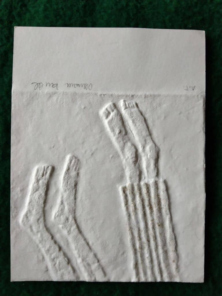 Slepotisky od Mistra O. Zoubka na bílém papíře, detailní záběr.