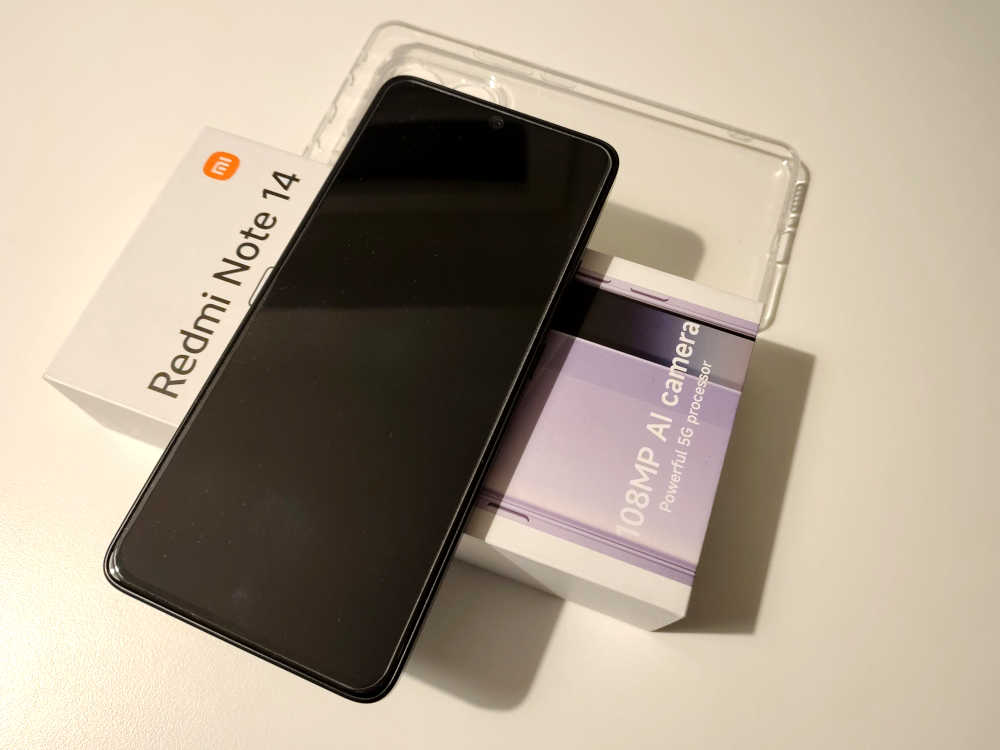 Moderní smartphone Redmi Note 14 s velkým displejem a černým designem.