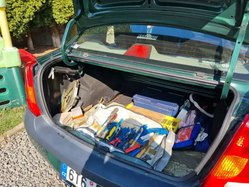 Garážovaný Dacia Logan, 2. majitel, s otevřeným zavazadlovým prostorem, nářadí a příslušenství uvnit.