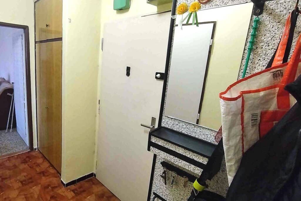 Vstupní dveře do bytu s bezpečnostními prvky a zámkem.