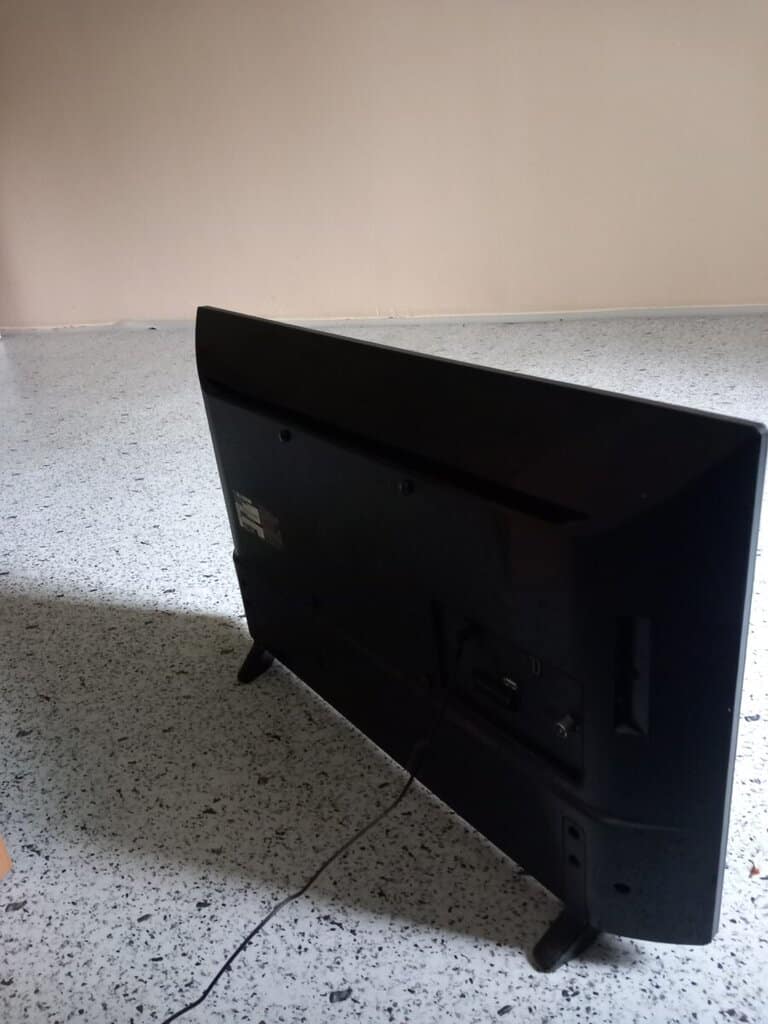 Černá televize s odhaleným zadním panelem a připojovacími porty.