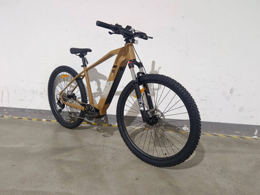 Elektrokolo horské s černými plášti a hnědým rámem, vhodné pro outdoorové jízdy.