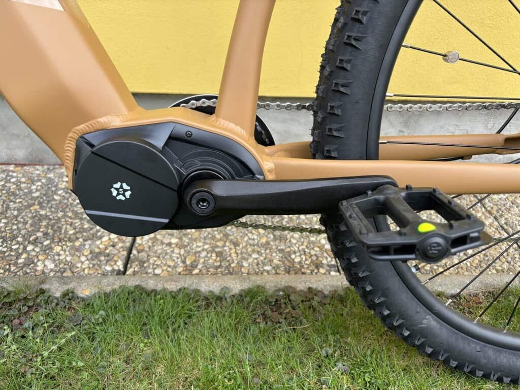 Elektrokolo s hnědým rámem a velkými pneumatikami, ideální pro terénní jízdu a dlouhé výlety.