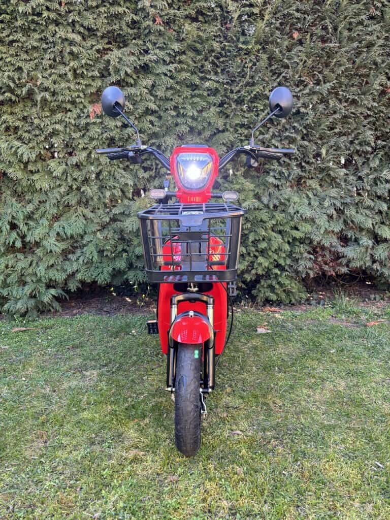 Elektrokolo s černým košíkem na přední straně, ideální pro městskou dopravu a volný čas.