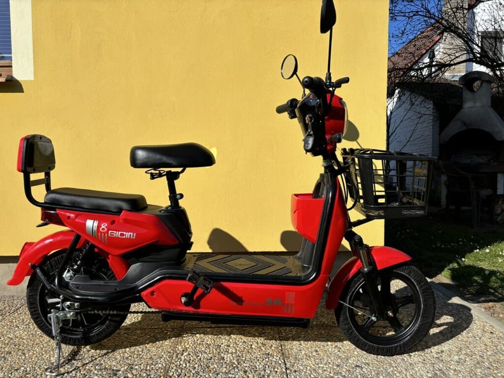 Elektrický skútr s košíkem a displejem, vhodný pro městské ježdění.