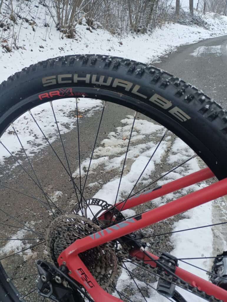 Horské kolo s plášti Schwalbe a zimní krajinou na pozadí, vhodné pro cyklistiku v náročném terénu.