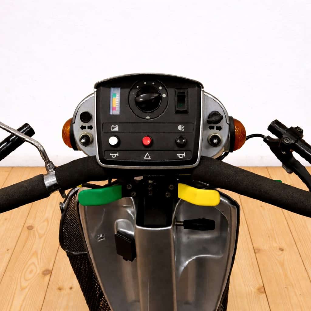 Řídicí panel elektrické koloběžky s tlačítky a displejem.