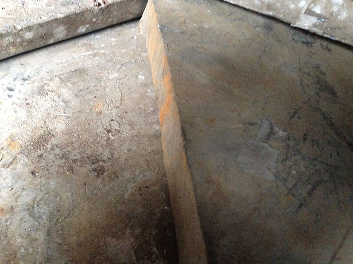 Hloubková stavební jáma s betonovým základem a dřevěnými konstrukcemi.